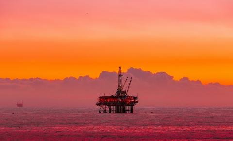 Oil rig at ocean sunset